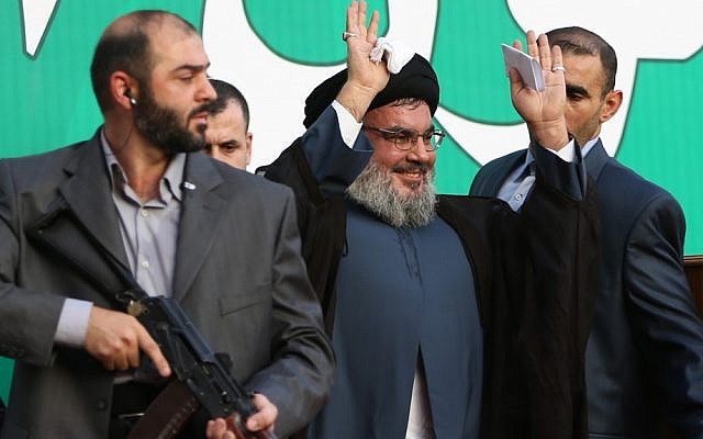 Hezbollah leader Hassan Nasrallah, center, escorted by his bodyguards, waves to a crowd of hundreds of thousands of supporters in Beirut, Lebanon in September, 2012. (Illustrative photo credit: AP/Hussein Malla)