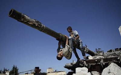 Children play on a Syrian tank destroyed during fighting in the Syrian town of Azaz, on the outskirts of Aleppo, September 2, 2012 (photo credit: AP/Muhammed Muheisen)
