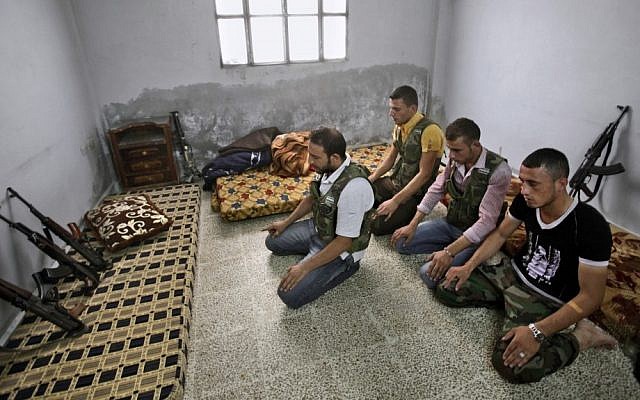 Syrian rebels pray at their headquarters near Aleppo, September 10 (photo credit: AP/Muhammed Muheisen)