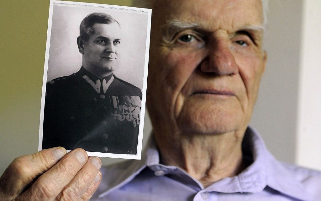 Franciszek Herzog holds a photograph of his father, also named Franciszek Herzog, in Hebron, Conn. Herzog's father and uncle both died in the Katyn Forest massacres. (photo credit: AP Photo/Jessica Hill)