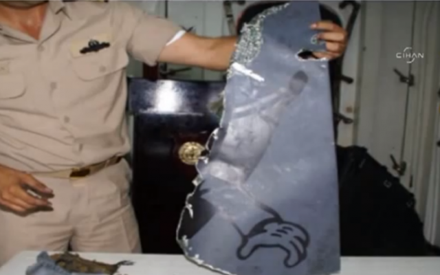 A Turkish military investigator with remains from the downed Turkish reconnaissance jet. (photo credit: image capture from YouTube clip uploaded by Today's Zaman)