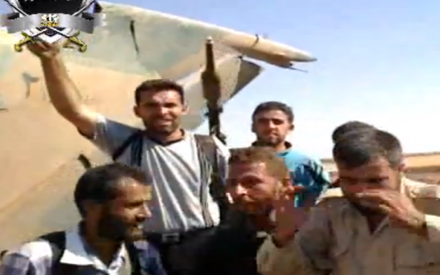 Syrian rebels in front of a downed Syrian warplane (photo credit: Image capture YouTube)