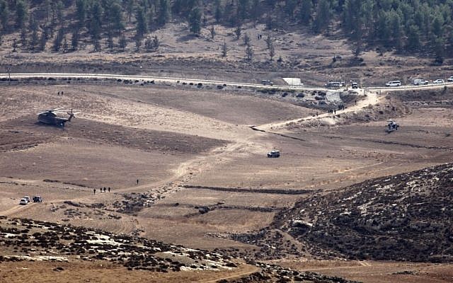 Israeli Army vehicles and helicopters are seen in an open area as they search for the remains of a drone in the Negev southern Israel on October 6, 2012. (photo credit: AP)
