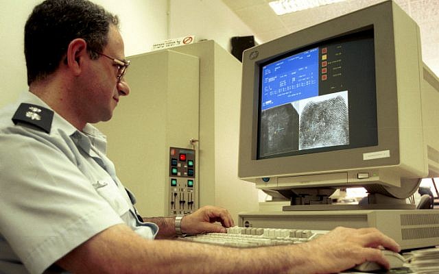 A policeman uses a computer to identify fingerprints in a laboratory at the police headquarters (Yossi Zamir/Flash90)