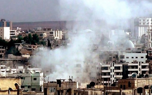 This image taken from video obtained from the Shaam News Network, which has been authenticated based on its contents and other AP reporting, purports to show smoke rising from buildings due to government forces shelling in Daraa, Syria, on Tuesday, Oct. 2, 2012. (photo credit: AP Photo/Shaam News Network via AP video)