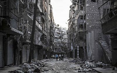 Syrian residents walk on a street among the debris of buildings damaged by heavy shelling in the southeast of Aleppo City, on October 27, 2012 (photo credit: AP Photo/Narciso Contreras)