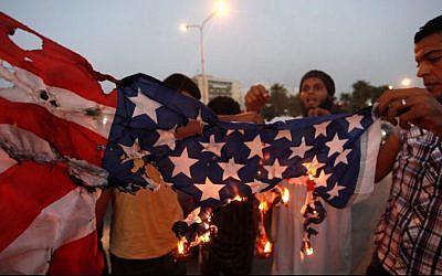 Dalam foto yang diambil pada 14 September 2012 ini, para pengikut Brigade Ansar al-Syariah Libya membakar bendera Amerika saat melakukan protes di depan Hotel Tibesti, di Benghazi, Libya.  (kredit foto: Foto AP / Mohammad Hannon)