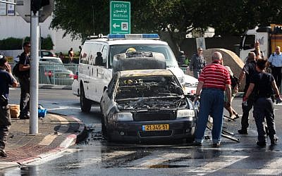 Police and security at the scene of where shrapnel from a rocket that was fired from Gaza and intercepted by the Iron Dome missile, hit a car in Holon, near Tel Aviv. November 18, 2012. (photo credit: Roni Schutzer/FLASH90)