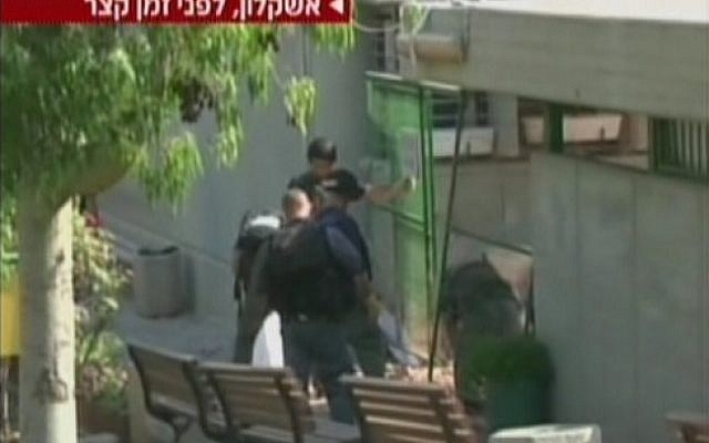 Police  inspect the damage to an Ashkelon school caused by a rocket fired from Gaza (screen capture/Channel 2)