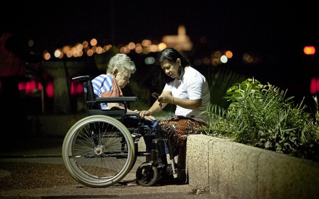 A Filipina caretaker with an elderly Israeli woman on the Tel Aviv boardwalk (photo credit: Moshe Shai/Flash90/File)
