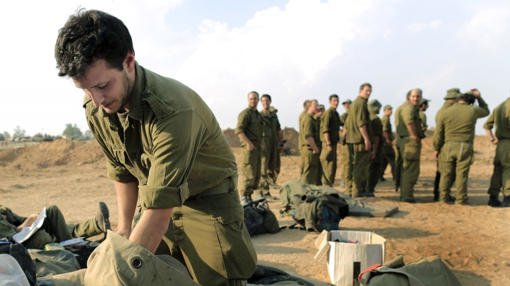 An Israeli reserve soldier packs his bag before leaving a deployment area near the Gaza border on Thursday, after a ceasefire agreement was agreed to by Israel and Hamas (photo credit: Tsafrir Abayov/Flash90)