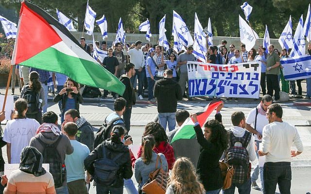 People wave Israeli flags during a demonstration supporting soldiers in Israel's military operation in Gaza, as they stand opposite a counter-protest at the Hebrew University in Jerusalem November 15, 2012. A Hamas rocket killed three Israelis north of the Gaza Strip on Thursday, drawing the first blood from Israel as the Palestinian death toll rose to 13 and a military showdown lurched closer to all-out war with an invasion of the enclave. Photo by Oren Nahshon / Flash 90.