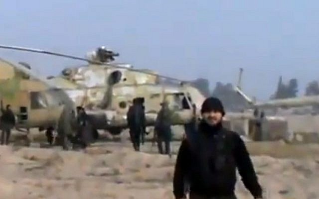 In this image taken from a video, Syrian rebels are shown capturing a helicopter air base near Damascus on Sunday (photo credit: AP/Ugarit News via AP video)