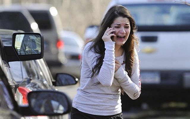 A woman waits to hear about her sister, a teacher, following a shooting at the Sandy Hook Elementary School in Newtown, Conn. on Friday, Dec. 14 (photo credit: AP/Jessica Hill)