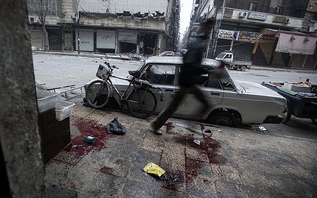 A Syrian man runs for cover during heavy fighting between Free Syrian Army fighters and government forces in Aleppo on Monday, Dec. 3, 2012. (photo credit: Narciso Contreras/AP)