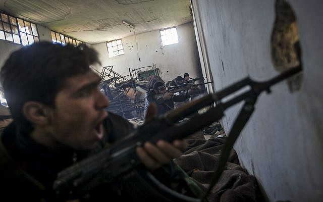 Free Syrian Army fighters aim their weapons as they chant religious slogans during heavy clashes with government forces north of Aleppo, Syria (photo credit: AP/Narciso Contreras)