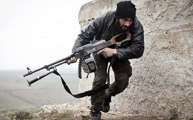 A Free Syrian Army fighter takes cover during fighting with the Syrian Army in Azaz, Syria on Monday. (photo credit: AP/Virginie Nguyen Huang)