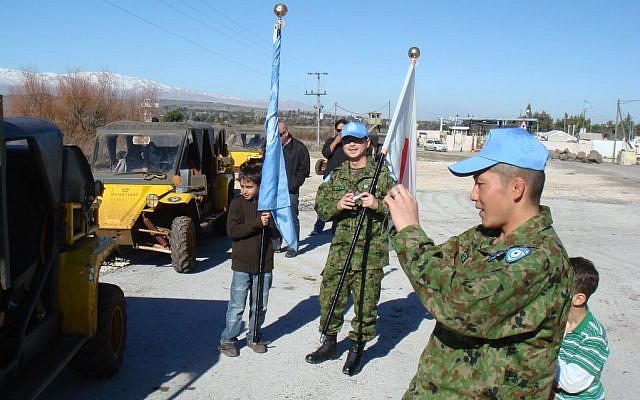 Japanese soldiers, part of the UN observer force in the Golan, take photos of jeeps near the Syrian border, in February 2009. (photo credit: Haim Azulay/Flash90)