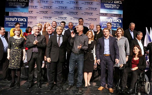 Yesh Atid Chairman Yair Lapid, center with tie, surrounded by his fellow party members after announcing their list for the upcoming Knesset elections in early December, 2012. Most of his list comprises new MKs, 19 of whom are entering the next Knesset. (photo credit: Yehoshua Yosef/Flash90)