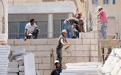 An illustrative photo of workers building a home in East Jerusalem's Ramat Shlomo neighborhood, June 2011. (photo credit: Gili Yaari/Flash90)