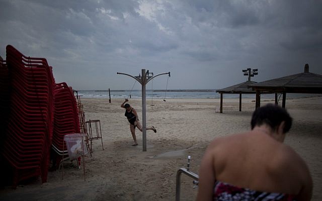 In December, two immigrants from the Ural region of the former Soviet Union rinse off after bathing in the Mediterranean Sea in the early morning, in Tel Aviv. Many Soviet immigrants gather at the beach for a traditional winter dip, the closest substitute to the freezing waters of the former Soviet Union (photo credit: AP Photo/Oded Balilty)