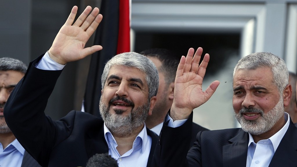 Exiled Hamas chief Khaled Mashaal, left, and Gaza's Hamas Prime Minister Ismail Haniyeh wave during a news conference upon Mashaal's arrival in the Gaza Strip on December 7. (photo credit: AP/Suhaib Salem, Pool)