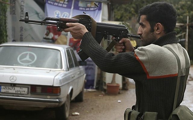 An illustrative photo of a Sunni gunman firing his weapon during clashes that erupted between pro and anti-Syrian regime gunmen in the northern port city of Tripoli, Lebanon in December 2012. (photo credit: AP/Hussein Malla)
