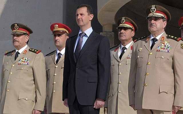 Syrian President Bashar Assad, center, stands next to Syrian Defense Minister Gen. Dawoud Rajha, right, and Chief of Staff Gen. Fahed al-Jasem el-Freij, left, during a ceremony to mark the 38th anniversary of the October 1973 Arab-Israeli war, in Damascus, Syria, in 2011. (AP Photo/SANA)