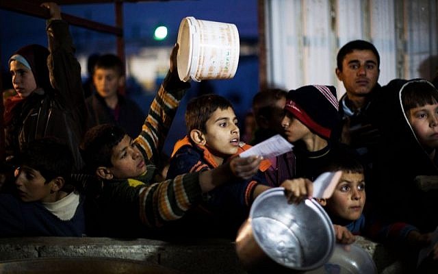 Syrian children wait in line for food at a refugee camp near the Turkish border, in Azaz, Syria, last December (photo credit: AP/Manu Brabo)