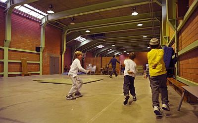 Kids participate in a physical education class at Maimonides, whose potential base of students is limited by its acceptance only of halachically Jewish pupils. (Cnaan Liphshiz via JTA)