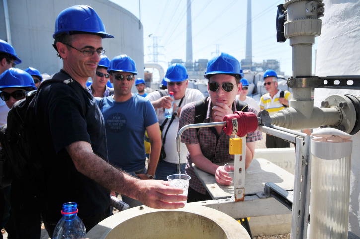 Visitors top up their glasses with treated sea water at a desalination plant near Hadera (photo credit: Shay Levy/Flash90)