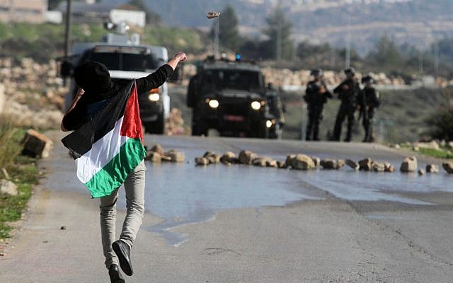 A Palestinian throwing stones at Israeli troops in the West Bank in December. (photo credit: Issam Rimawi/Flash90)