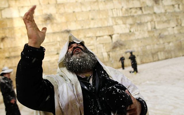 A man at the Western Wall, perhaps praying for rain of the non-freezing variety. (photo credit: Nati Shohat/Flash90)