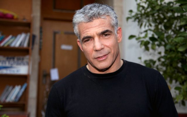 Yesh Atid leader Yair Lapid speaks to reporters outside his house on Friday, January 25 (photo credit: Gideon Markowicz/Flash90)