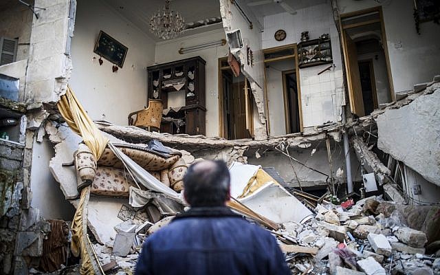 A civilian looks at a destroyed home in Aleppo, Syria, Thursday, Jan. 3, 2013 (photo credit: AP/Andoni Lubaki)
