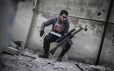 In this Friday, Jan. 18, 2013 photo, a sniper takes position on a roof during combat in the neighborhood of Saif Al-Dawlah in Aleppo, Syria (photo credit: AP/Andoni Lubaki)