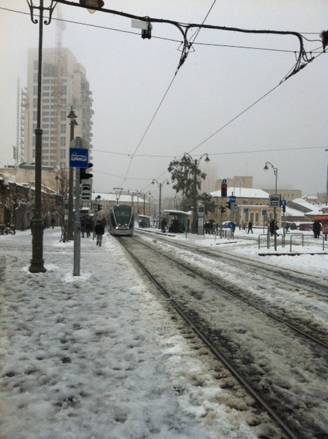 A light rail arrives at the slush-covered Mahane Yehuda stop. (photo credit: Greg Tepper/Times of Israel staff)
