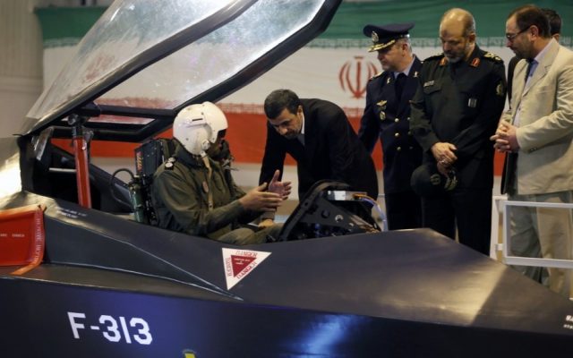 Former Iranian President Mahmoud Ahmadinejad, center, listens to an unidentified pilot during a ceremony to unveil Iran's newest fighter jet, the Qaher-313, in Tehran, Iran, February 2, 2013 (AP/Mehr News Agency/Younes Khani)