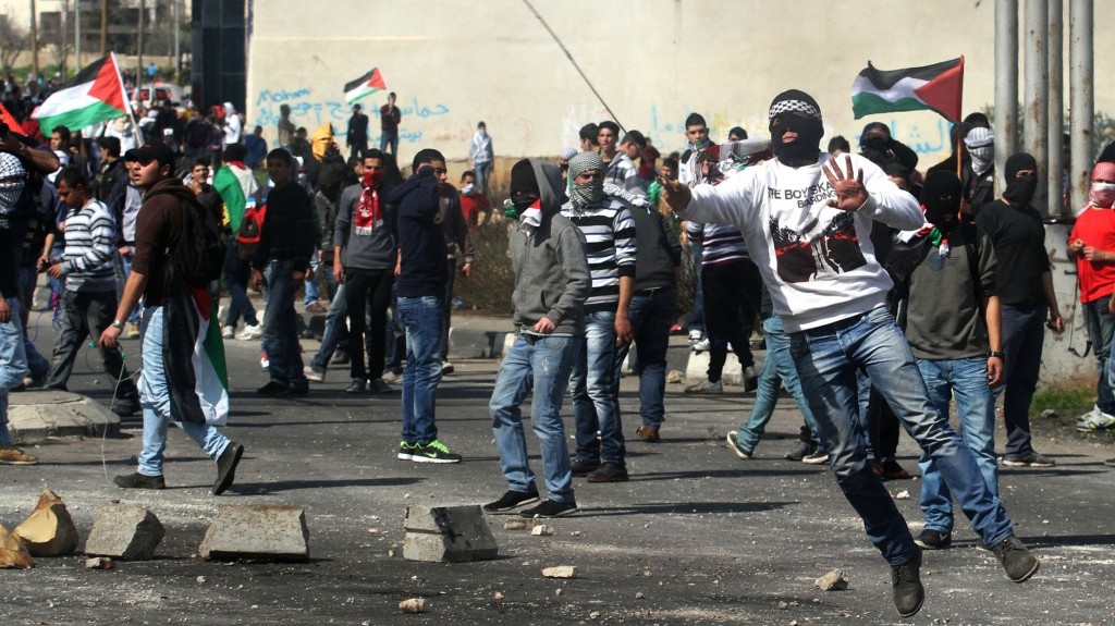 Palestinian protesters hurl rocks at Israeli soldiers during clashes next to Ofer prison, near the West Bank city of Ramallah, on Thursday (photo credit: Issam Rimawi/Flash90)