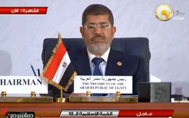 A visibly unamused Egyptian President Mohammed Morsi at Wednesday's meeting of the Organization of Islamic Cooperation summit in Cairo (photo credit: screen capture YouTube)