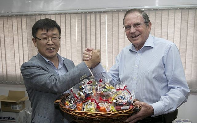(L to R) D.S. Choi, CEO of Samsung Israel, and Uri Slonim, chairman of Variety Israel, with one of Samsung's Purim baskets (Photo credit: Eran Lam)