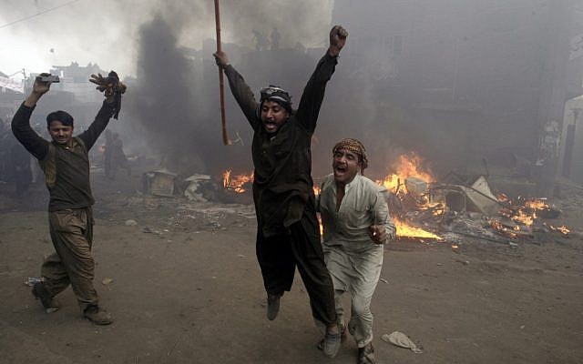Pakistani men, part of an angry mob, react after burning belongings of Christian families, in Lahore, Pakistan, Saturday, March 9, 2013. (photo credit: AP/K.M. Chaudary)