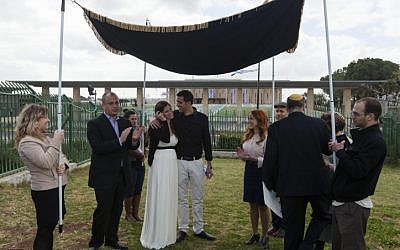 MK Stav Shaffir (to the right of wedding couple) participates in a Reform Jewish wedding ceremony in front of the Knesset, in protest at the Orthodox Rabbinate's monopoly on marriage licensing and the lack of civil marriage in Israel. (photo credit: Flash90)