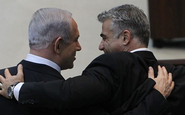 Israeli Prime Minister Benjamin Netanyahu embraces Yesh Atid leader Yair Lapid after addressing the Knesset ahead of the swearing-in of the new government, March 18, 2013. (Miriam Alster/FLASH90/File)