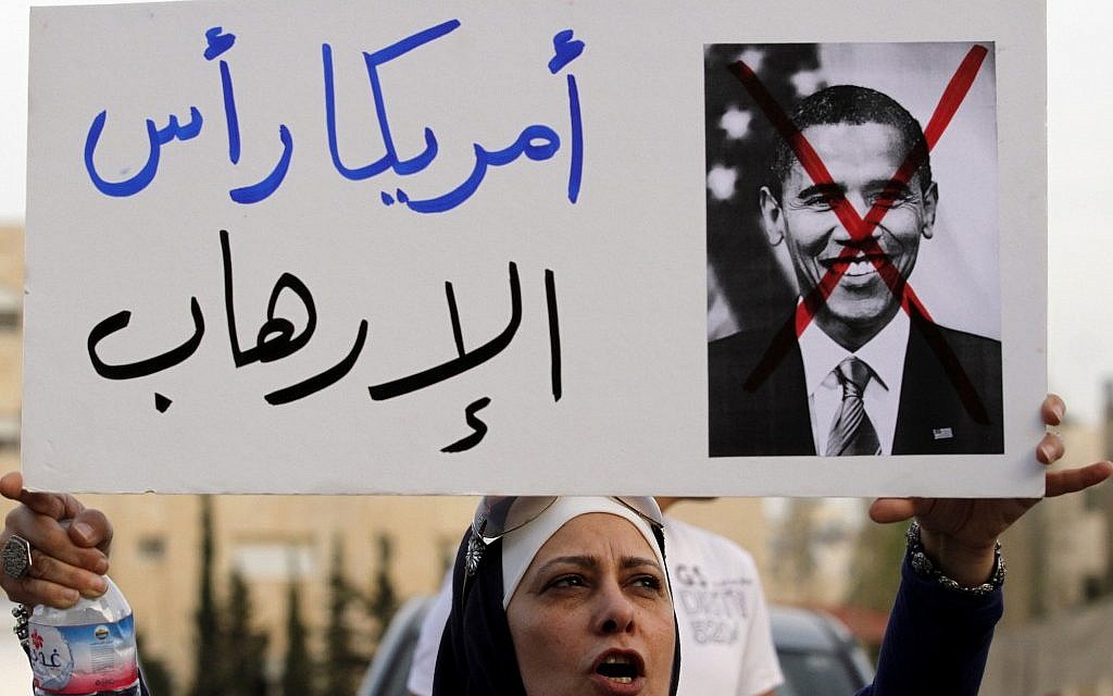 A Jordanian protester holds a placard that reads "America is the head of terrorism," during a protest near the Israeli Embassy against the visit by US President Obama to the region, in Amman, Jordan, Thursday, March 21, 2013. (photo credit: AP/Raad Adayleh)