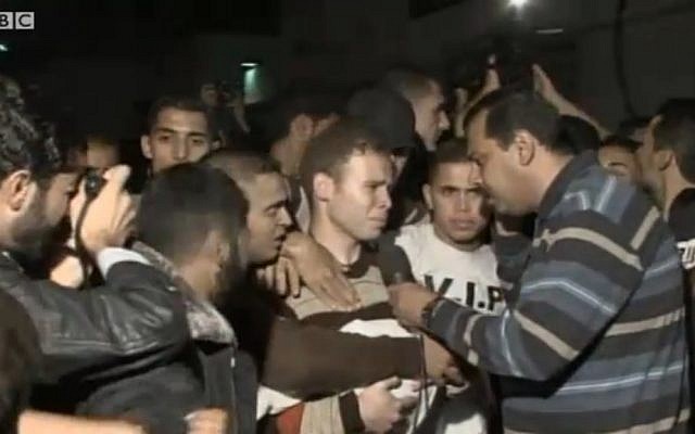 Jihad Mishrawi speaks to the media, while carrying the body of his son Omar, on November 15, 2012. (photo credit: screenshot BBC)
