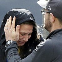 An unidentified Boston Marathon runner is comforted as she cries in the aftermath of two blasts that exploded near the finish line of the Boston Marathon in Boston, Monday, April 15, 2013 (photo credit: AP/Elise Amendola)