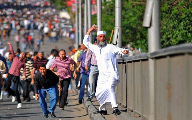 An Egyptian man throws a stone during clashes between rival groups of protesters in Cairo, Egypt, Friday, April 19, 2013. (photo credit: AP/Mostafa Darwish)