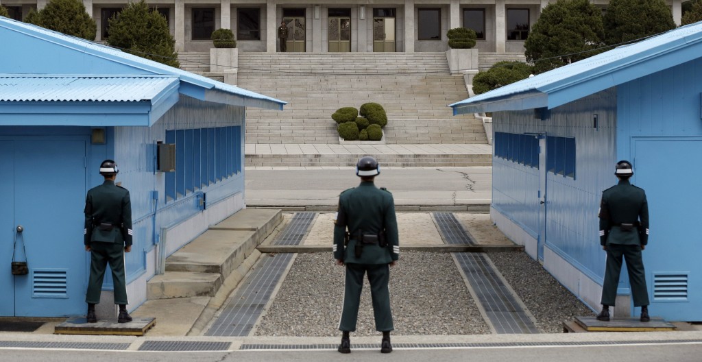 A North Korean soldier, center top, looks at the southern side as South Korean soldiers stand guard at the border village of Panmunjom, which has separated the two Koreas since the Korean War, in Paju, north of Seoul, South Korea, Wednesday, April 10, 2013.