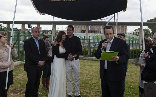 Rabbi Gilad Kariv, the head of the Reform movement in Israel, performs a Reform Jewish wedding ceremony in front of the Knesset, on March 18, 2013. To the left of the couple stands Labor party MK and secretary-general Hilik Bar. (photo credit: Flash90)